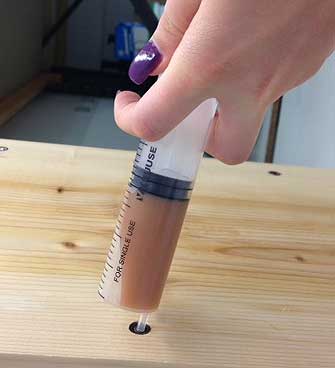 Injection of PU Liquid into a timber via an injector.